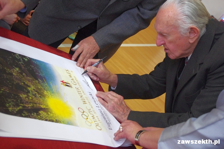 Eugeniusz Lewacki w dniu swoich 90. uodzin skada autograf na replice plakatu Igrzysk w St.Moritz