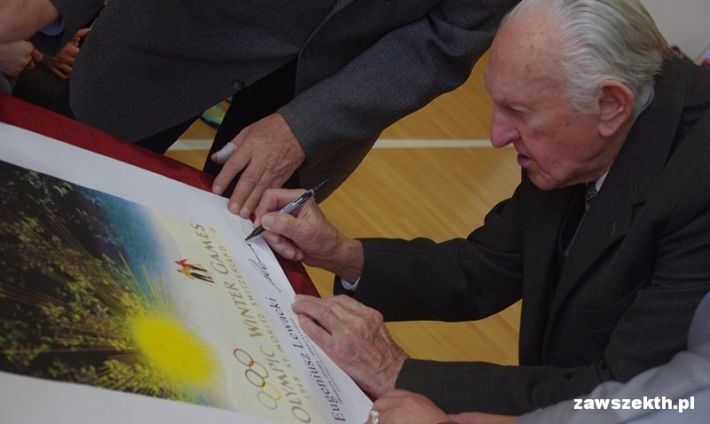 Eugeniusz Lewacki skada autograf na replice plakatu olimpijskiego